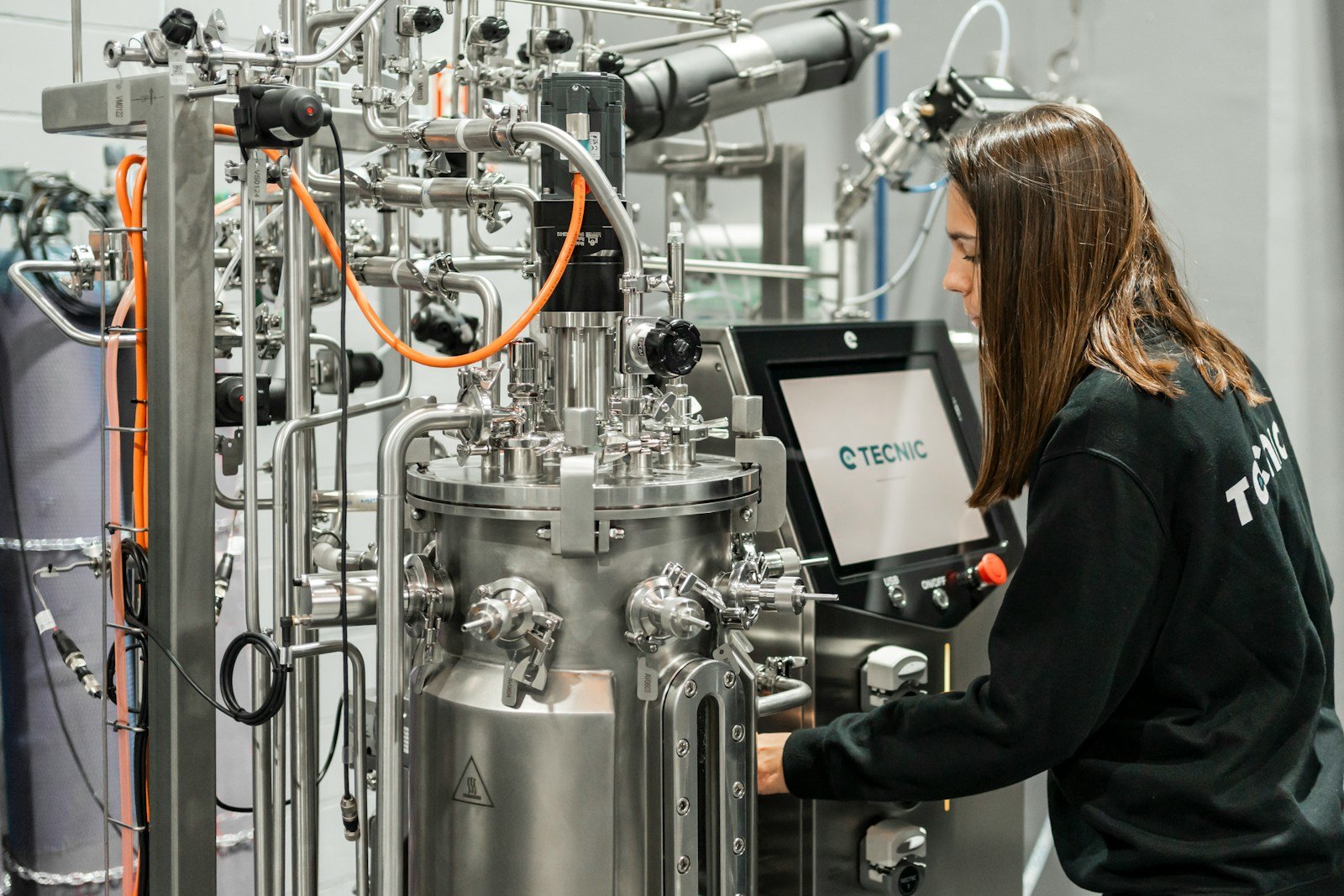 A woman operates complex scientific equipment.